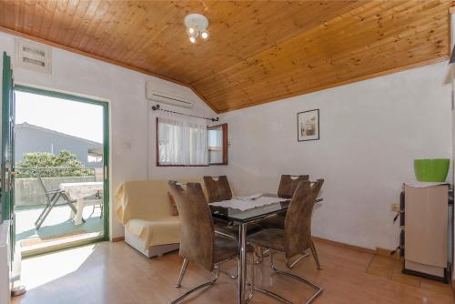 a dining room with a table and chairs and a couch at Apartments Romic in Jadrija