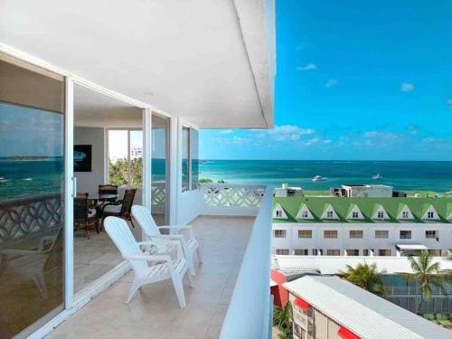 a balcony with white chairs and a view of the ocean at Penthouse Barlovento para 19 personas in San Andrés