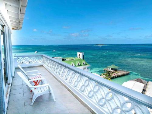 a balcony with a white chair and the ocean at Penthouse Barlovento para 19 personas in San Andrés