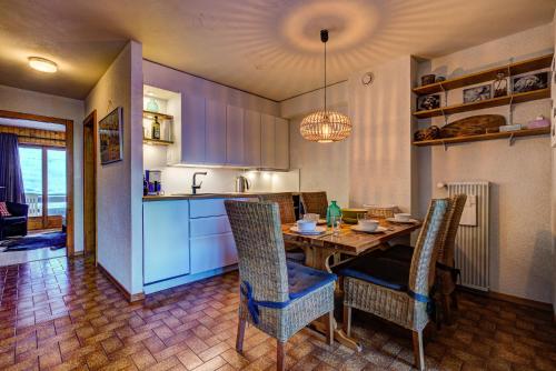cocina y comedor con mesa y sillas en Appartement Bellevue 207, en La Tzoumaz