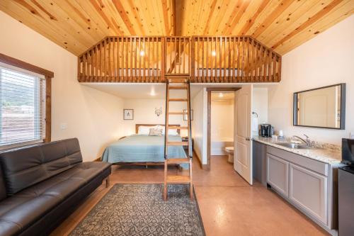 a loft bed in a tiny house with a bedroom at Gooseberry Lodges Zion National Park Area in Apple Valley