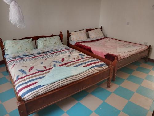 two beds sitting next to each other in a room at Triple Eden Resort - Naivasha in Naivasha