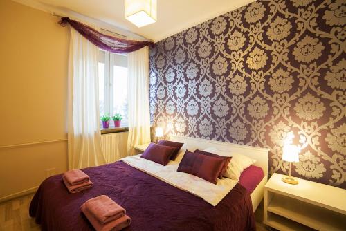 1 dormitorio con cama morada y ventana en Key Apartments Chmielna, en Varsovia