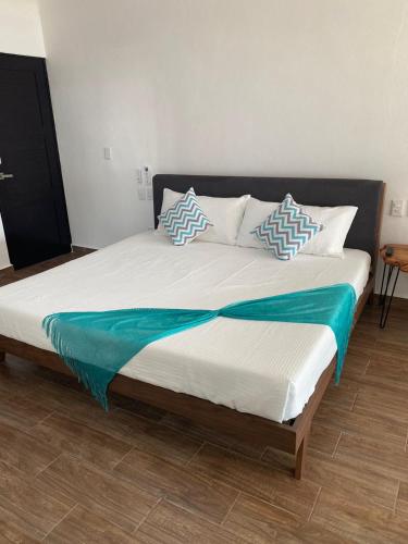 a large bed with blue and white pillows on it at Penthouse Ave Paraiso en Manzanillo 505 Apt 16b in Manzanillo