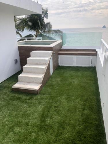 a balcony with grass and stairs overlooking the ocean at Penthouse Ave Paraiso en Manzanillo 505 Apt 16b in Manzanillo