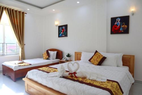 a bedroom with two beds with white sheets at Khách sạn Thái Bình in Con Dao