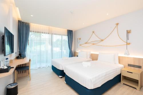 Postel nebo postele na pokoji v ubytování Panwaburi Beachfront Resort - SHA Extra Plus