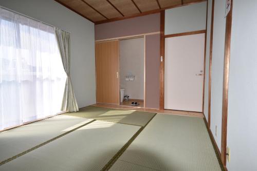 Guest House Fuku-chan في Kaiyo: غرفة فارغة مع نافذة كبيرة وأرضية