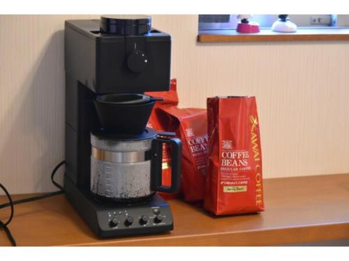 eine Kaffeemaschine auf einer Theke neben einer Schachtel in der Unterkunft Guest House Fukuchan - Vacation STAY 34483v in Kaiyo