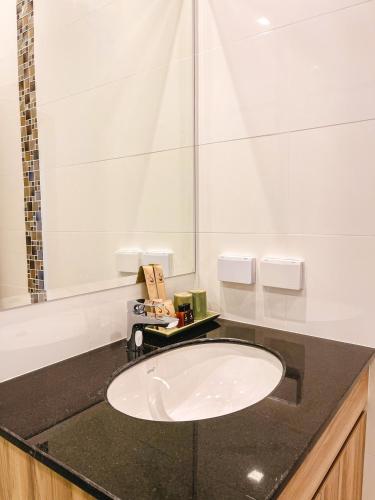 a bathroom with a white sink on a black counter at Sukruethai Hotel Chiang Mai - โรงแรมสุขฤทัย เชียงใหม่ in Chiang Mai