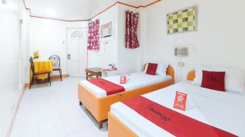Habitación de hotel con 2 camas y escritorio en RedDoorz @ Eros Travellers Pensione, en Iloilo City
