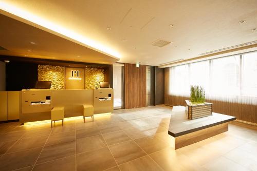a lobby with a desk and chairs in a building at hotel MONday KYOTO MARUTAMACHI in Kyoto