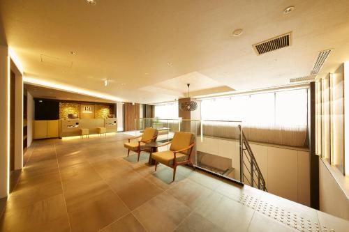 a living room with a table and chairs and a kitchen at hotel MONday KYOTO MARUTAMACHI in Kyoto