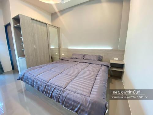 um quarto com uma cama grande num quarto em The S อพาร์ทเม้นท์ em Ban Pra Dok