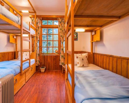 a room with two bunk beds and a window at Zen Manali by Keekoo Stays in Manāli