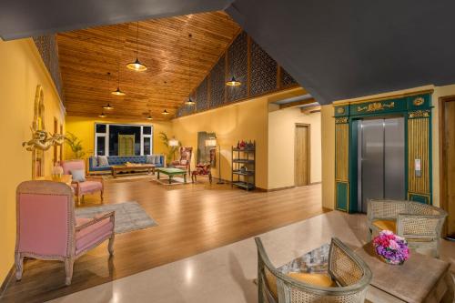 a large living room with chairs and a couch at The Atman Dharamshala by Leisure Hotels in Dharamshala