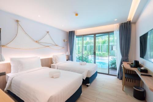 Postel nebo postele na pokoji v ubytování Panwaburi Beachfront Resort - SHA Extra Plus