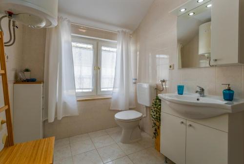 baño con lavabo y aseo y ventana en NINA deluxe SUPERIOR 5 star apartment, your piece of heaven by the sea & park, en Novigrad Istria