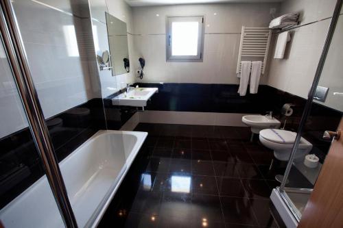 a bathroom with two sinks and a tub and two toilets at Hotel Allon Mediterrania in Villajoyosa