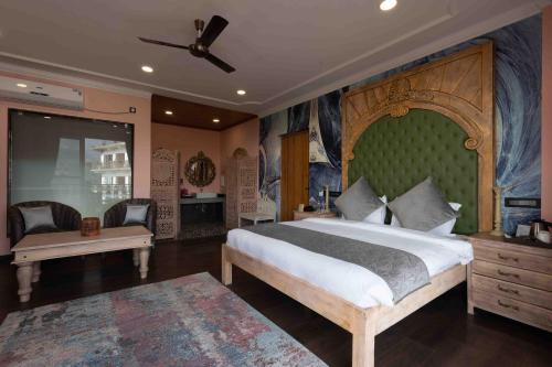 a bedroom with a large bed with a green headboard at The Atman Dharamshala by Leisure Hotels in Dharamshala
