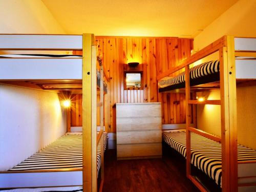 two bunk beds in a room with wooden walls at Studio Bellentre, 1 pièce, 4 personnes - FR-1-329-5 in Bellentre