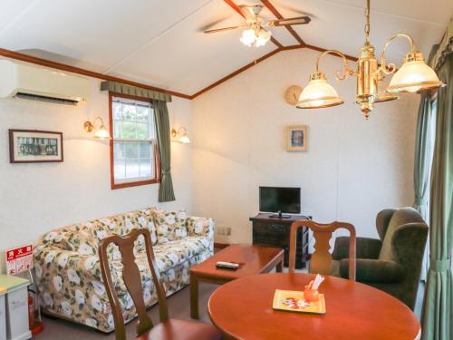 a living room with a couch and a table at コテージスターハウス今帰仁 in Nakijin