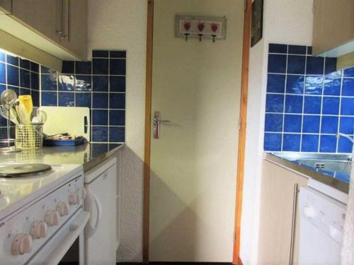 a kitchen with blue tiles on the counters and a stove at Studio Bellentre, 1 pièce, 3 personnes - FR-1-329-3 in Bellentre