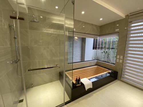 La salle de bains est pourvue d'une douche et d'une baignoire. dans l'établissement 台南安平包棟民宿 - 定言豪宅館, à Anping