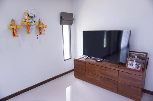 浦阿สวัสดีปัวโฮมสเตย์ Sawaddee Pua Homestay的木质梳妆台上方的平面电视