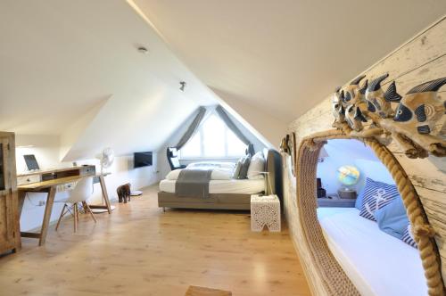 ein Schlafzimmer mit einem Bett und einem Schreibtisch im Dachgeschoss in der Unterkunft Elbhus Hamburg in Moorwerder