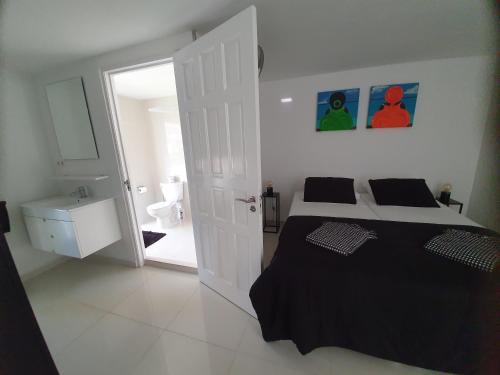 a bedroom with a bed and a door to a bathroom at STUDIO S at JAN THIEL Curacao in Jan Thiel