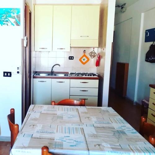 a kitchen with a table and a sink and a stove at La Casa di Anna in Lampedusa