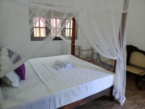 a bedroom with a bed with a canopy and a window at sunny mound unawatuna close by sri yoga shala in Unawatuna