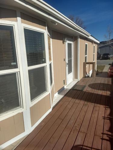a house with a wooden deck with windows at Curt's cozy room rentals in Wendover