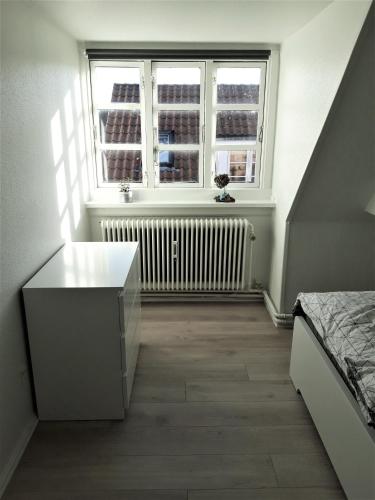 a bedroom with a bed and a window and a radiator at Nabo til domkirken in Viborg