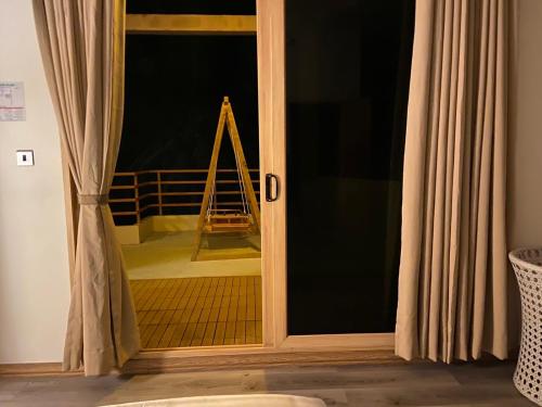 a sliding glass door with a ladder in a room at Finolhu Beach Guest House in Felidhoo
