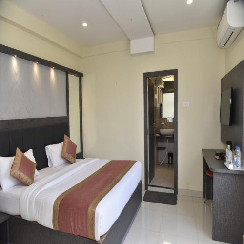 a hotel room with a large bed and a bathroom at HOTEL TRIDEV GRAND in Varanasi