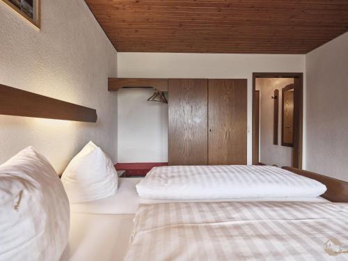 a bedroom with two beds and a wooden ceiling at Landgasthof Adler Pelzmühle in Biederbach Baden-Württemberg