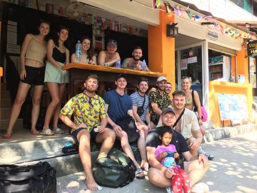 een groep mensen die poseren voor een foto voor een gebouw bij Voyagers Hostel in Phi Phi Don