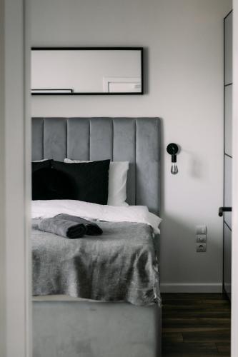 a bedroom with a large bed with a gray headboard at B15-Blue Lagoon in Győr