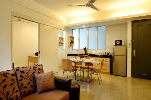 a kitchen and living room with a table and chairs at One-Stop Residence & Hotel in Kuala Lumpur