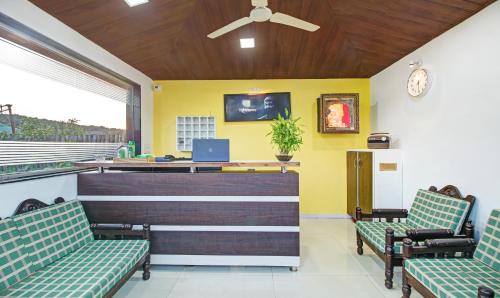a waiting area with two chairs and a reception desk at Treebo La Paradise in Mahabaleshwar