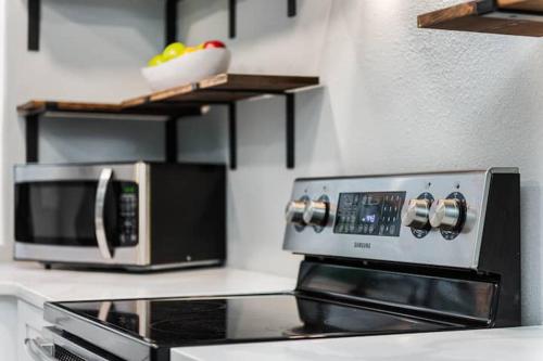 a microwave and a toaster oven on a kitchen counter at Modern House in Clearwater with access to a Shared Swimming Pool in Safety Harbor