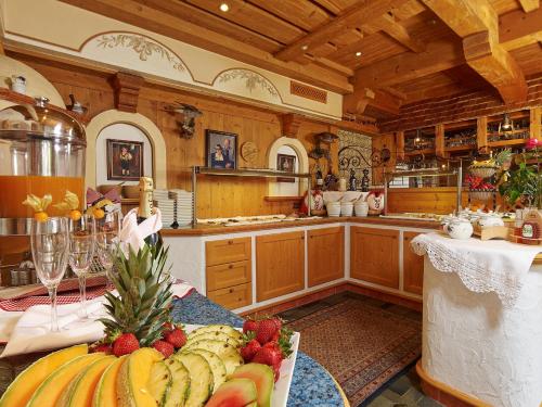 a large kitchen with a table with fruit on it at Hotel Ländenhof Superior in Mayrhofen