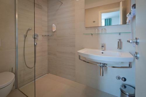 a bathroom with a sink and a shower at Hotel Bor in Krk