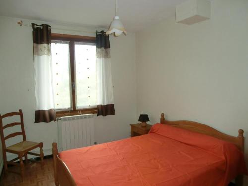 a bedroom with a bed and a chair and a window at LOU FILADOUR 4 PERSONNES 1er étage in Jausiers