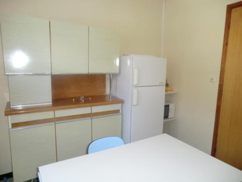 a kitchen with white cabinets and a white refrigerator at LOU FILADOUR 4 PERSONNES 1er étage in Jausiers