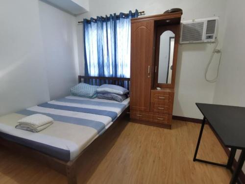 um pequeno quarto com uma cama e um espelho em Room in Studio - Mesaverte Residences Afs Suites em Cagayan de Oro