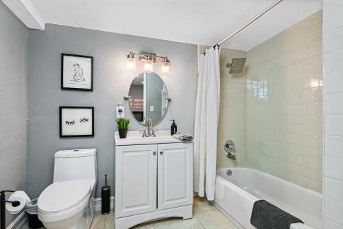 a bathroom with a toilet and a sink and a tub at Modern House in Clearwater with access to a Shared Swimming Pool in Safety Harbor