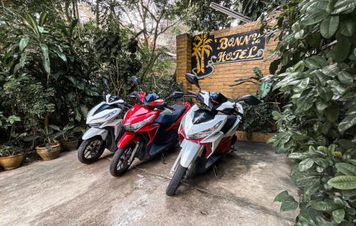 two motorcycles parked next to a sign with plants at Bonny Hotel 4 Floors No Elevator in Lamai